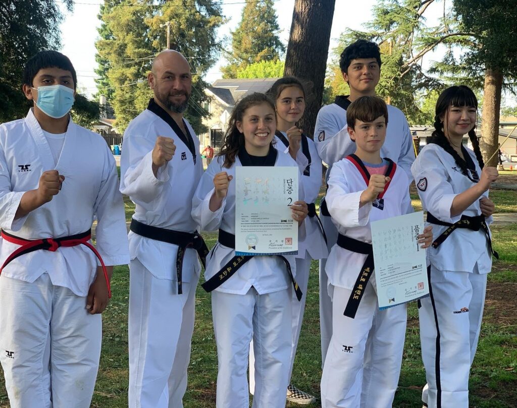 Master Gerardo with his black belt students showing their diplomas in Redwood City, CA.