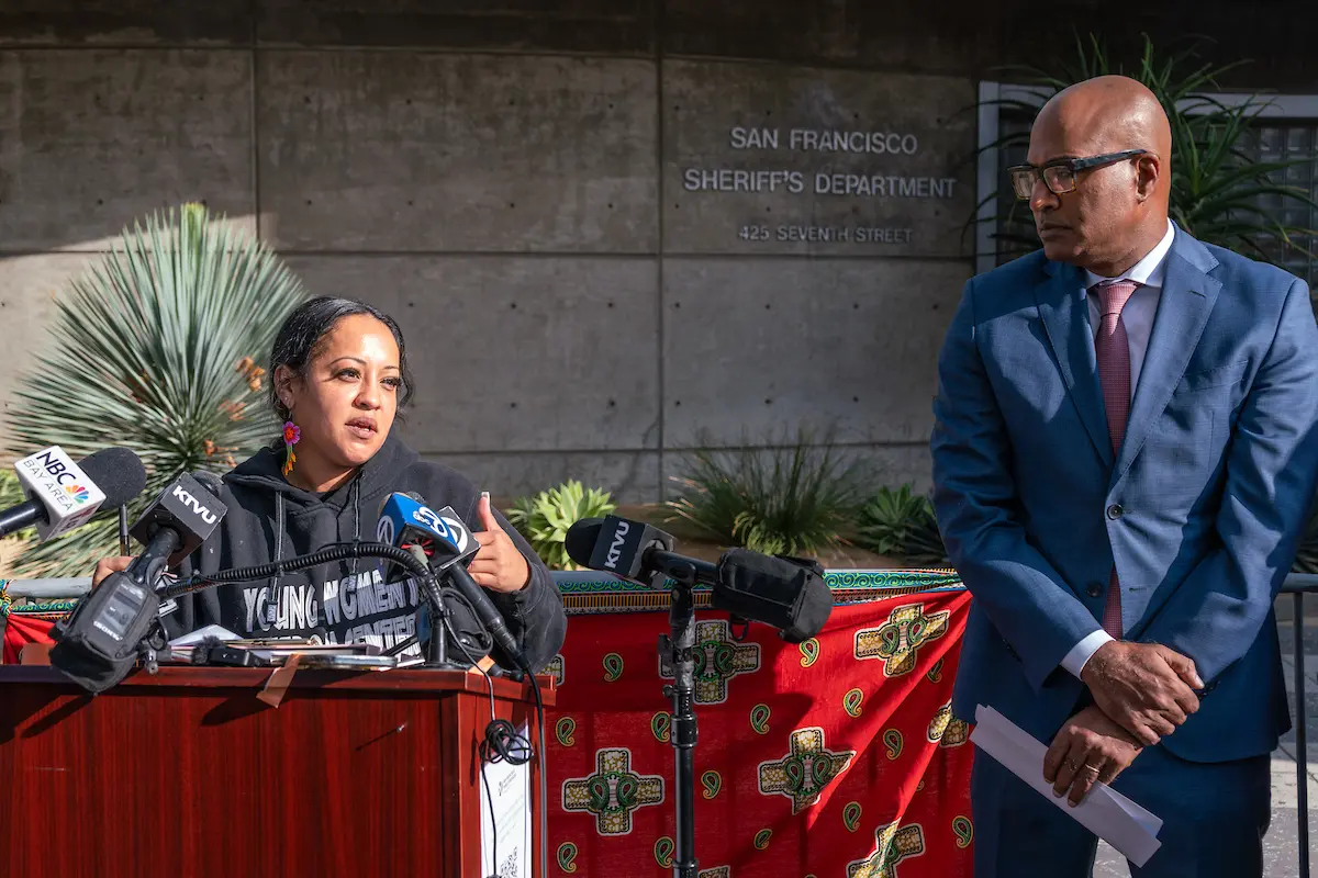 La directora ejecutiva del Centro para la Libertad de Mujeres Jóvenes, Julia Arroyo, abrió la manifestación con apasionados comentarios que alegaban que la Oficina del Sheriff de San Francisco estaba violando la política estatal, las protecciones constitucionales y la dignidad humana básica.