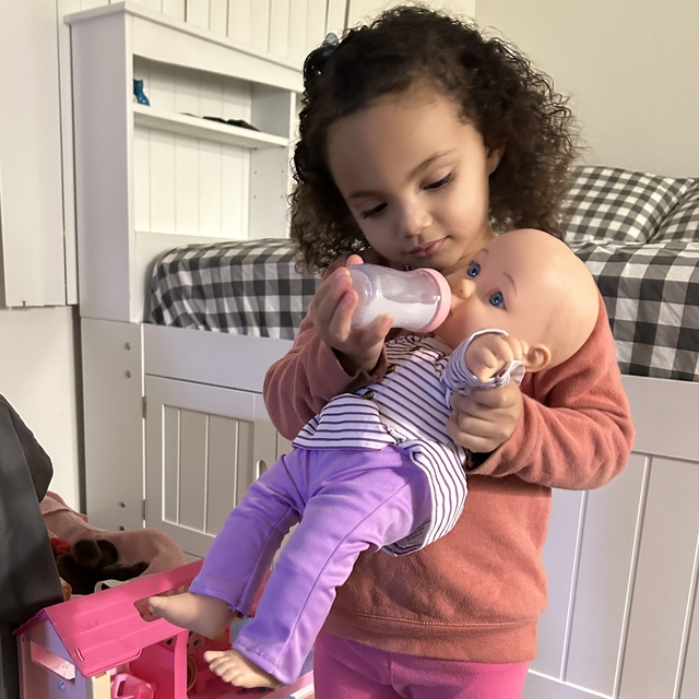 Makayla alimenta a su muñeca dentro de la habitación que comparte con su madre en Casa Esperanza, el centro de vivienda de apoyo permanente que le dio a la familia un lugar al que llamar hogar.